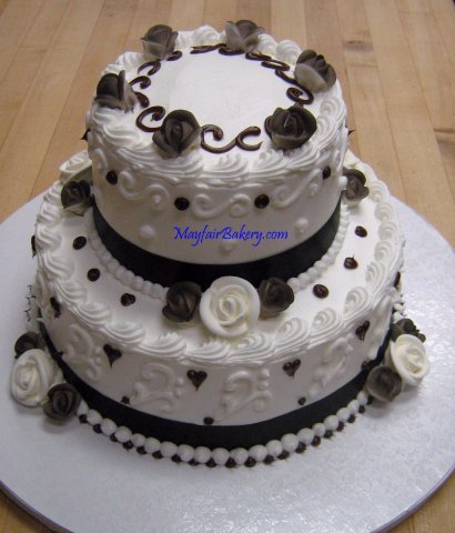 2 tier black and white - 2 tier with black ribbon and chocolate dots, black airbrush on the roses.6&quot; on 9&quot; tiers. 7 pounds. Serves 35.